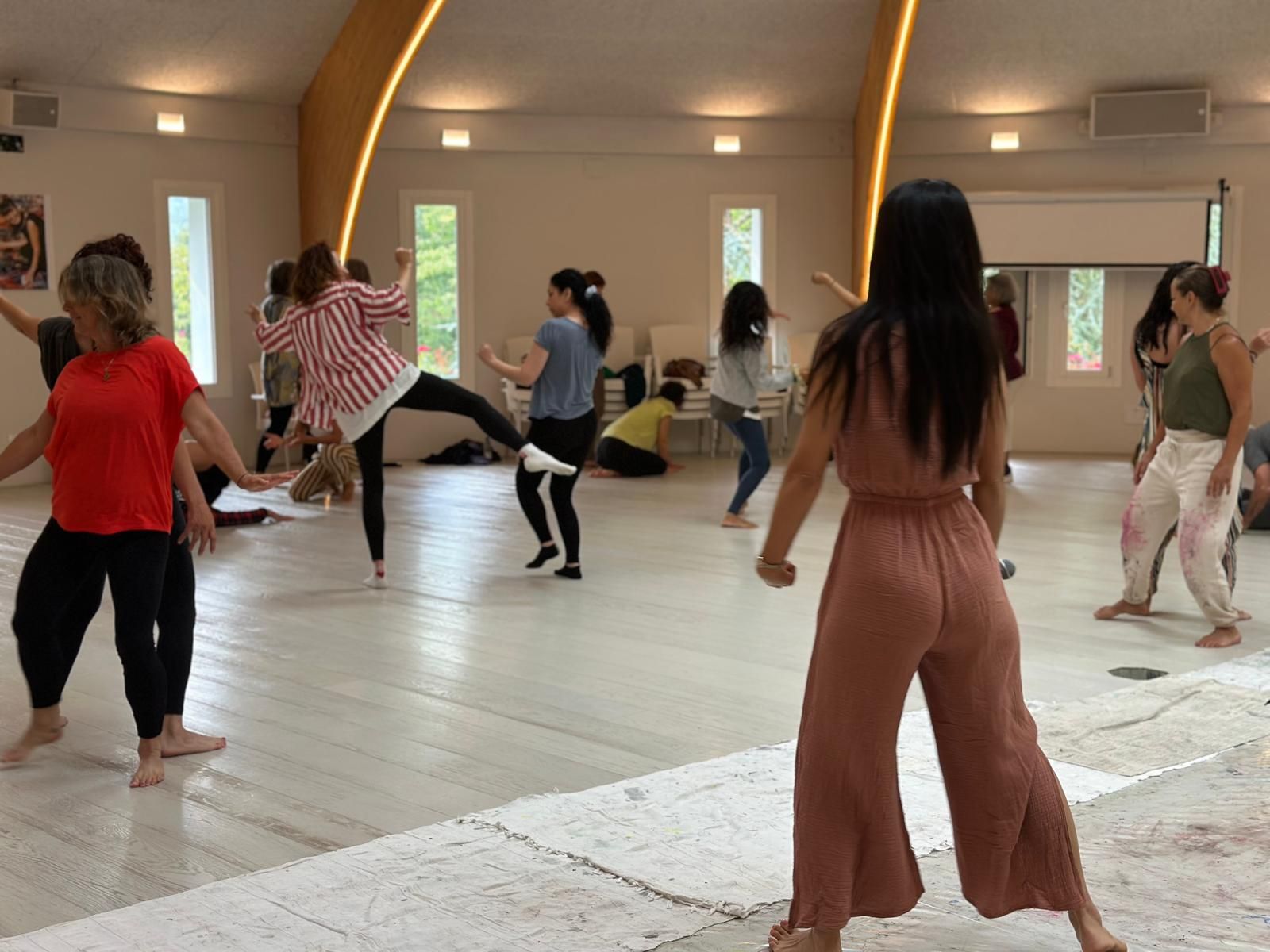 A group of participants dancing inside the meditation dome during Dynamic Meditation practice.